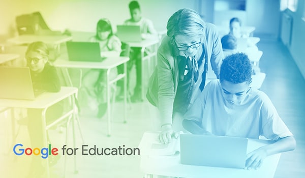 Google for Education - Teacher hunching over student's shoulder while he works on a laptop