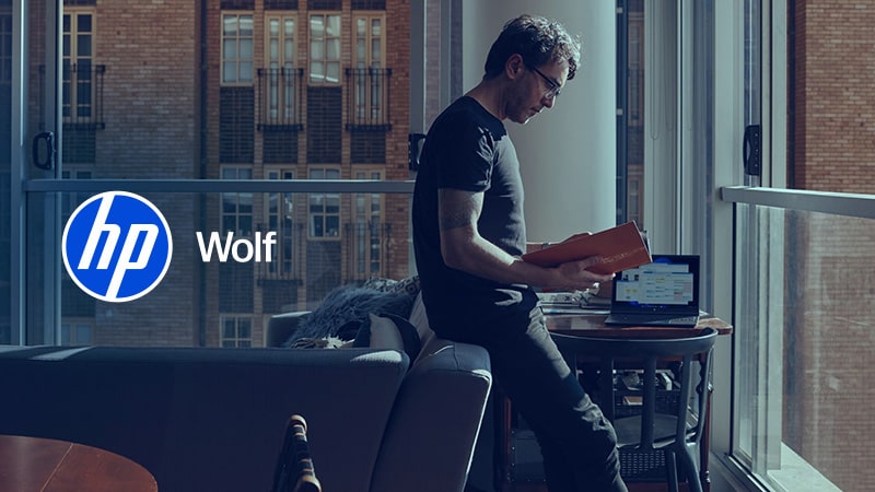 Man leaning against sofa with open book in hands